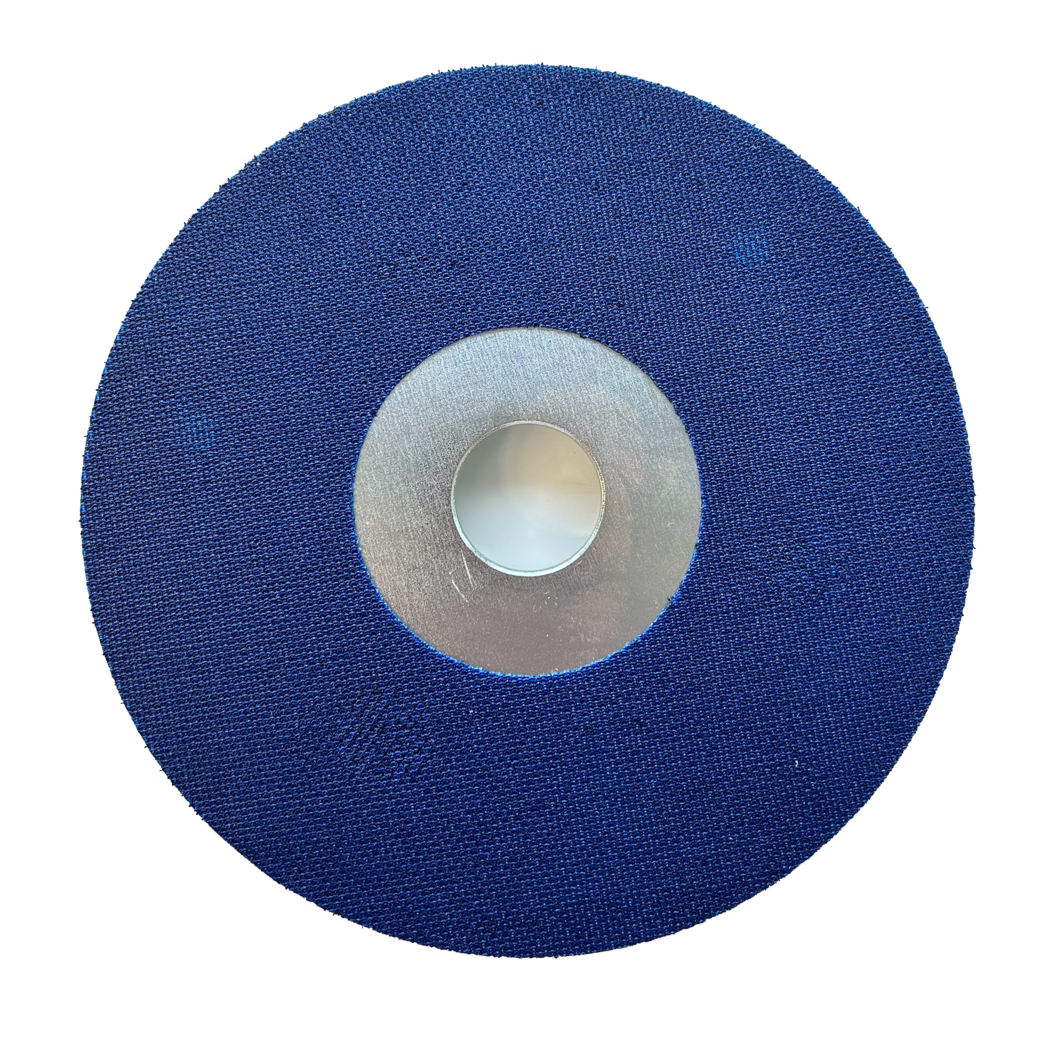 PALLMANN_Dummy_Satellitenscheibe_Klett_180mm Hochauflösende Draufsicht auf eine runde, blau beschichtete Schleifscheibe mit texturierter Stoffoberfläche und zentralem Metallkern. Die Scheibe ist gleichmäßig rund, die feine gewebte Körnung auf der blauen Fläche ist gut erkennbar; ein silberner Metallring umgibt die leicht vertiefte zentrale Bohrung. Das Objekt ist auf weißem Hintergrund fotografiert, mit klaren Kanten und gleichmäßiger Ausleuchtung, die Struktur und das Material der zum Schleifen/Polieren verwendeten Scheibe für rotierende Werkzeuge hervorhebt.
