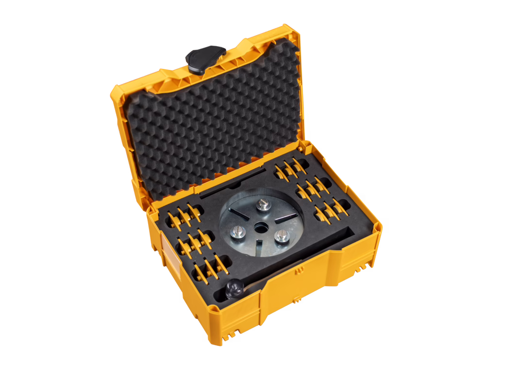 PALLMANN_dummy_DIAMOND SEGMENT TRANSPORTBOX open_zudem_2019-08 Offener gelb-orangefarbener Kunststoffkoffer mit eierkistenartiger Schaumstoffeinlage im Deckel und maßgefertigten Schaumeinsätzen, die einen runden Metallwerkzeugkopf und mehrere kleine Aufsätze halten, vor weißem Hintergrund fotografiert.